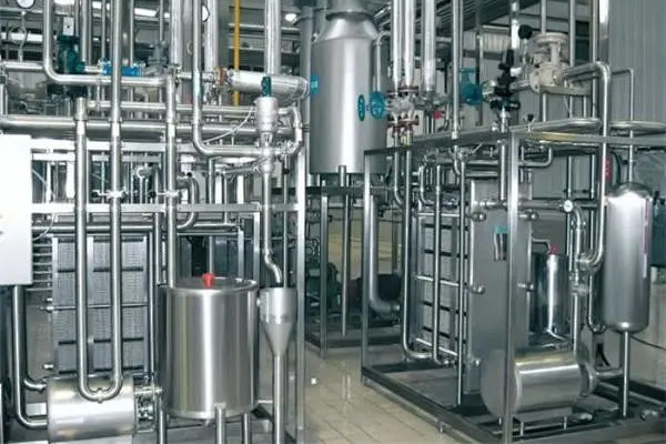 Stainless steel tanks, piping and skid-mounted process equipment inside a clean industrial plant